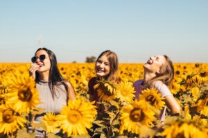 Mujeres felices sonriendo en un campo de girasoles