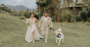 Pareja de esposos corriendo en el campo con su perro