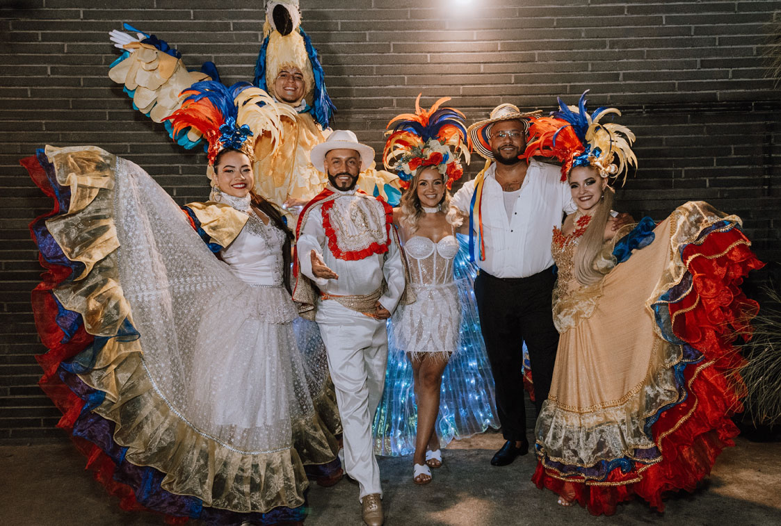 pareja de esposos en su fiesta de compromiso posando con la bailarines folclóricos