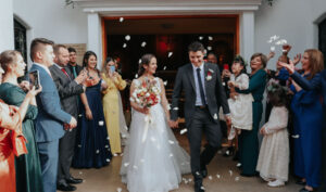 Familia celebrando una boda a la salida de la iglesia y señora con enterizo azul