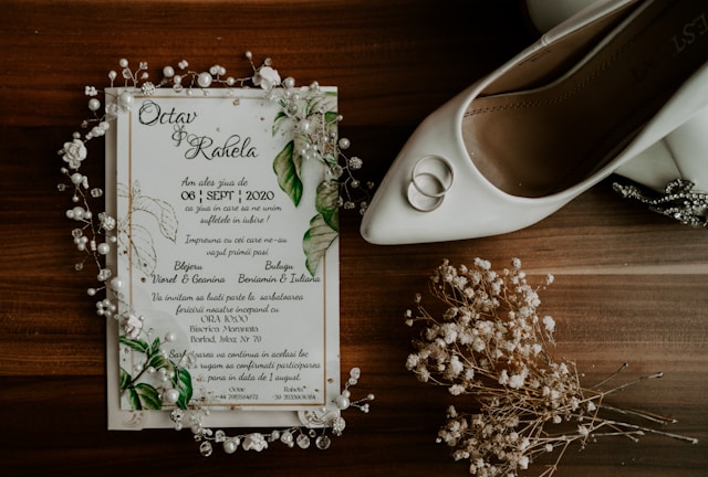 Invitación de matrimonio decorado con flores, zapato de la novia y argollas.