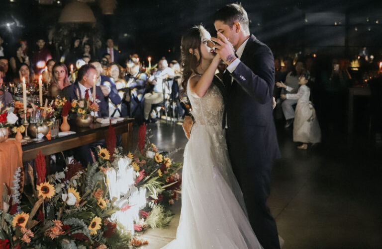 Pareja de esposos bailando en la celebración de su matrimonio junto a su familia
