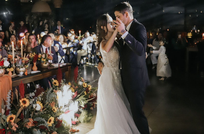 Pareja de esposos bailando en la celebración de su matrimonio junto a su familia