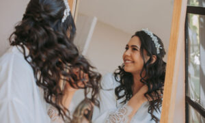 novia peinándose frente al espejo, haciéndose ondulaciones para su boda