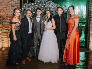 foto de novios con invitadas de vestido largo