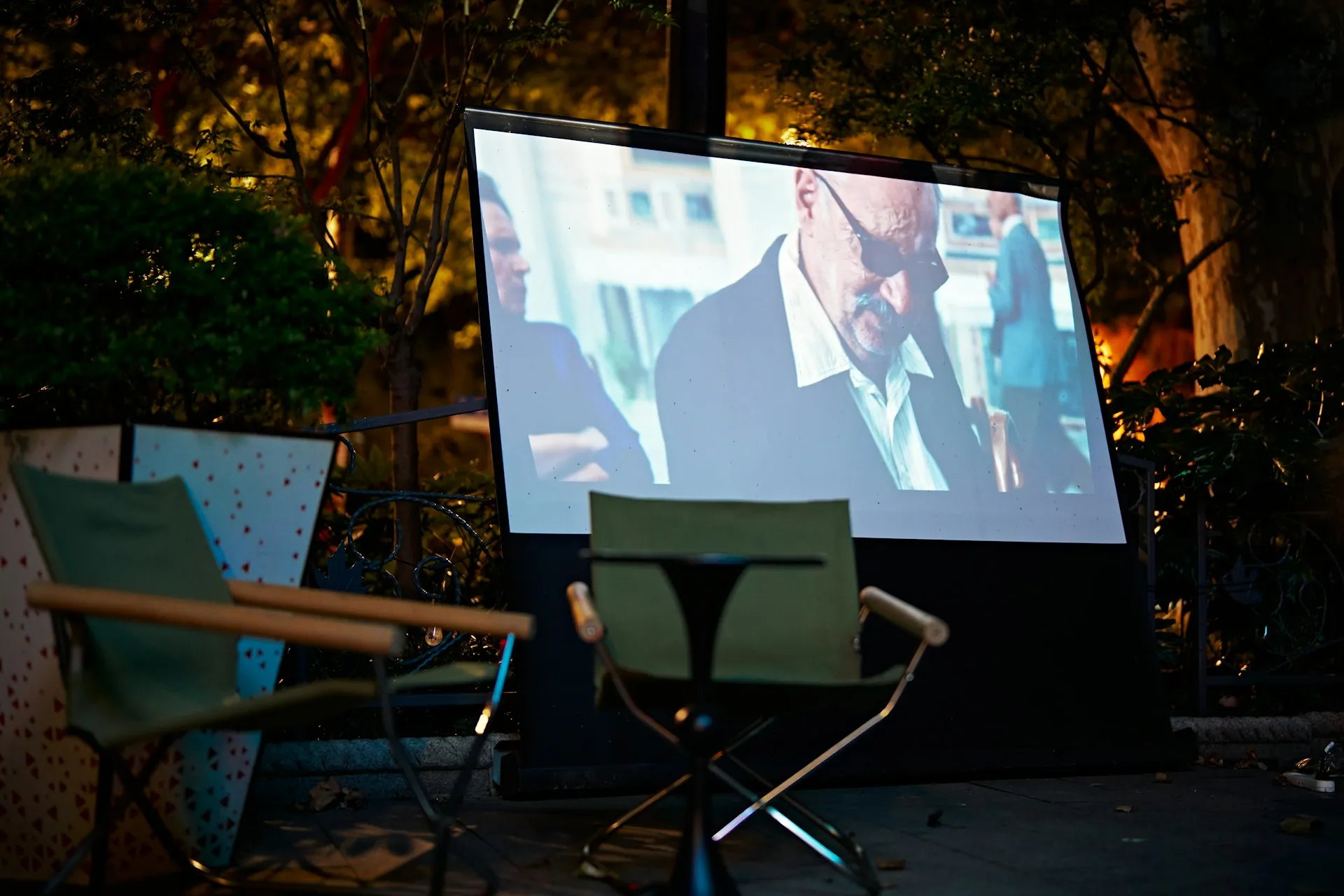 Pantalla de cine al aire libre ilumina una celebración nocturna