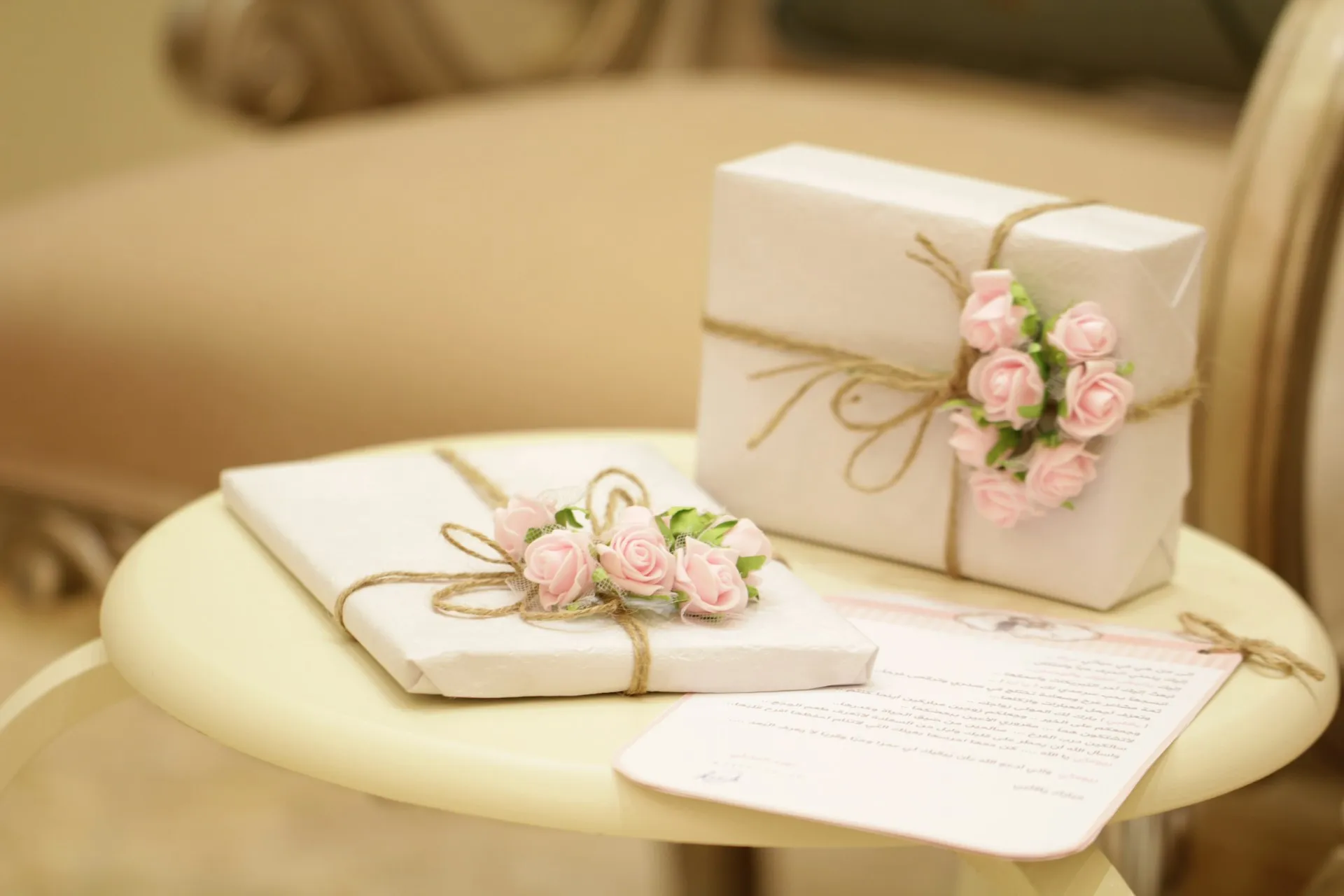 Regalo de bodas envuelto con flores rosadas sobre una mesa